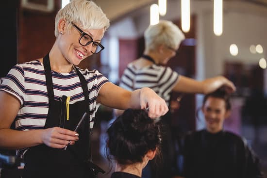 Smiling female getting her hair trimmed at a salon