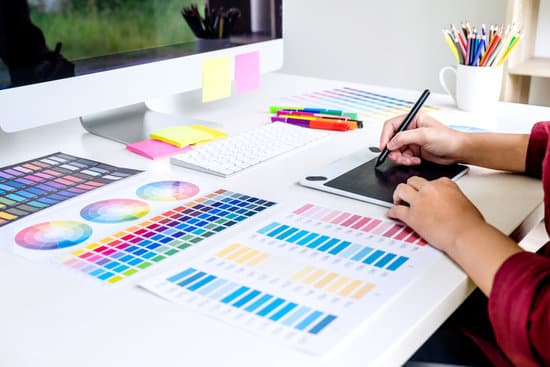 Image of female creative graphic designer working on color selection and drawing on graphics tablet at workplace.